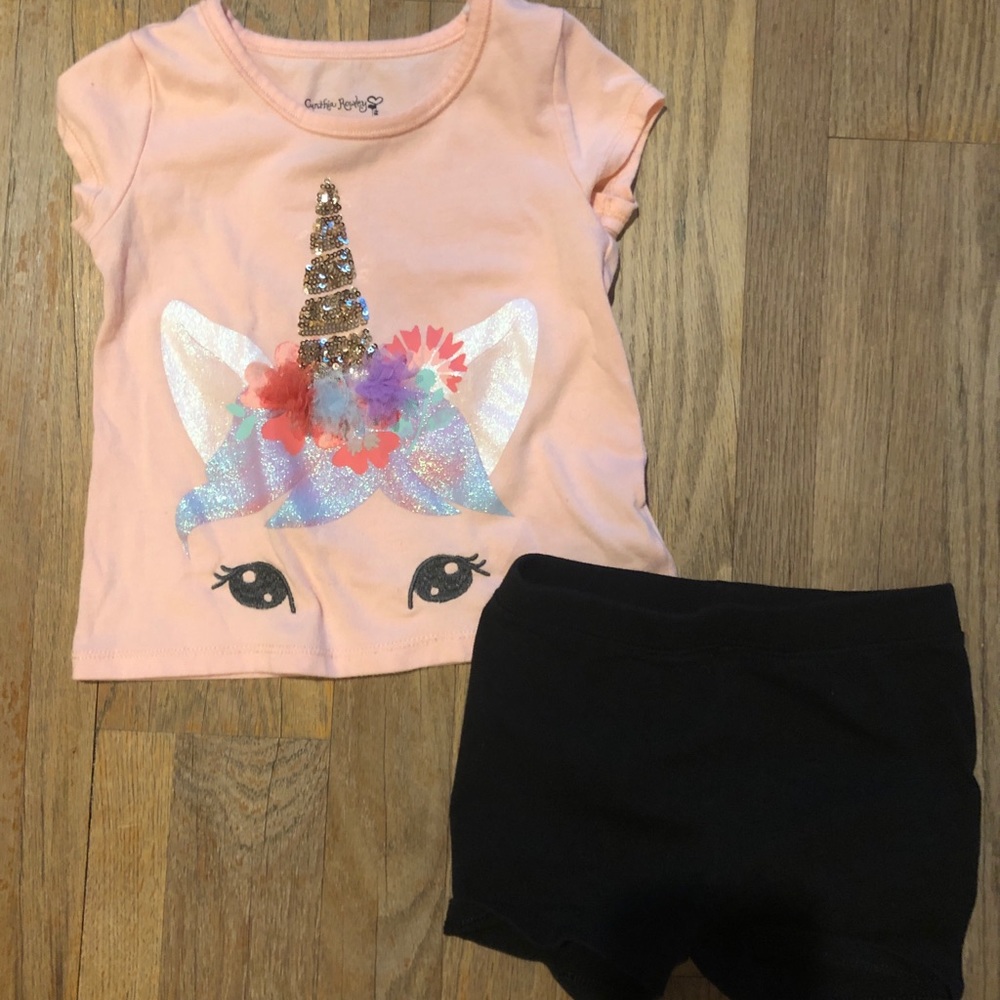 Unicorn top and black shorts.